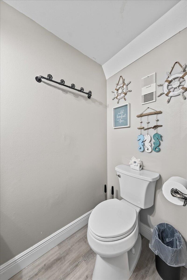 bathroom featuring vaulted ceiling, hardwood / wood-style flooring, and toilet