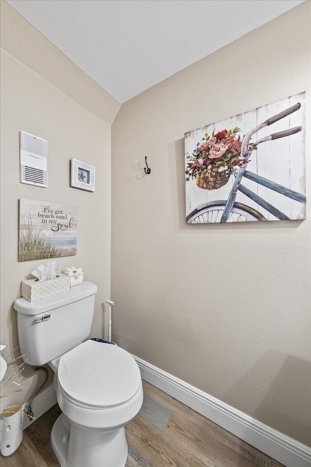 bathroom with hardwood / wood-style floors, vaulted ceiling, and toilet