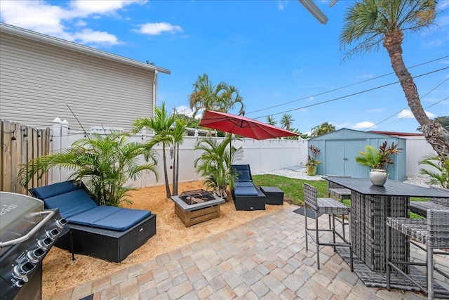 view of patio featuring a shed and an outdoor fire pit