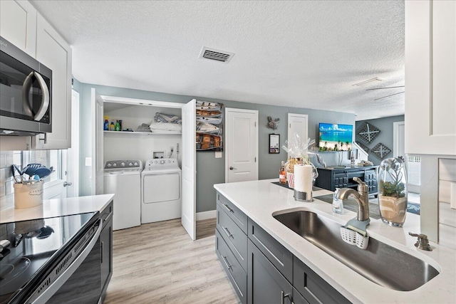 kitchen featuring sink, electric range, washer and dryer, gray cabinets, and white cabinetry