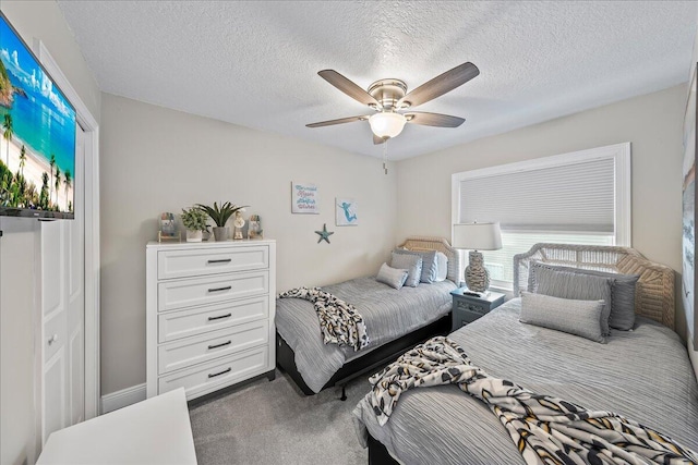 carpeted bedroom with ceiling fan and a textured ceiling