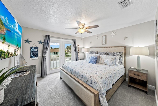 carpeted bedroom with ceiling fan, access to exterior, a textured ceiling, and french doors