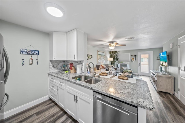 kitchen with white cabinets, sink, appliances with stainless steel finishes, tasteful backsplash, and kitchen peninsula