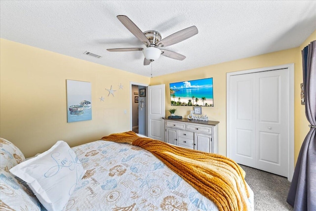 bedroom featuring ceiling fan, a closet, carpet floors, and a textured ceiling