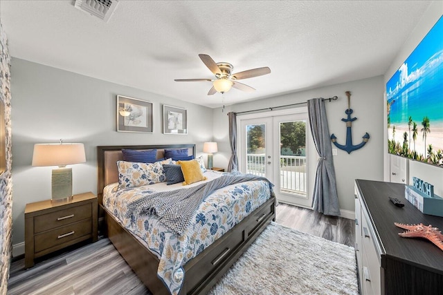 bedroom featuring access to exterior, ceiling fan, french doors, a textured ceiling, and light wood-type flooring