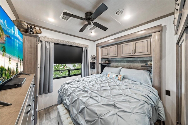 bedroom featuring ceiling fan, ornamental molding, and dark wood-type flooring