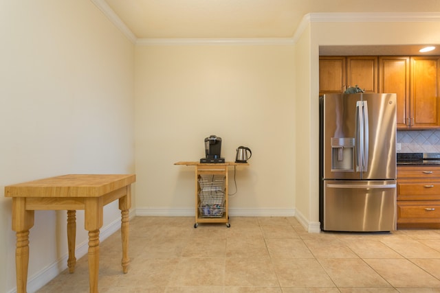 kitchen with stainless steel fridge, light tile flooring, tasteful backsplash, and crown molding