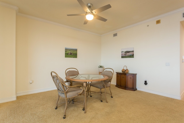 carpeted dining area featuring ornamental molding and ceiling fan