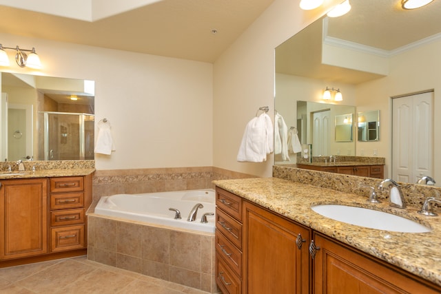 bathroom featuring shower with separate bathtub, vanity with extensive cabinet space, tile flooring, and dual sinks