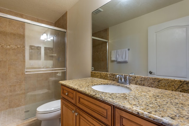 bathroom featuring oversized vanity, toilet, a textured ceiling, and walk in shower