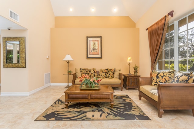 tiled living room with plenty of natural light and high vaulted ceiling