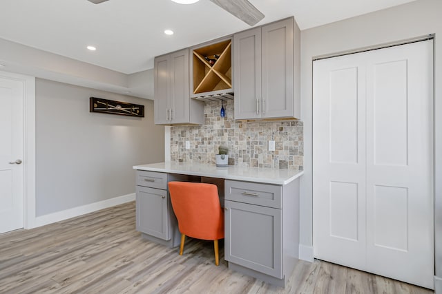 kitchen with gray cabinets, tasteful backsplash, and light hardwood / wood-style floors