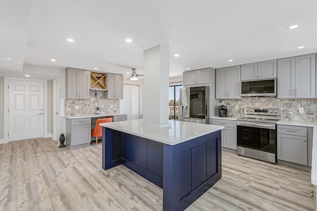 kitchen with light wood-type flooring, gray cabinetry, ceiling fan, and stainless steel appliances