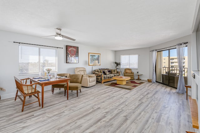 living room with ceiling fan and light hardwood / wood-style flooring