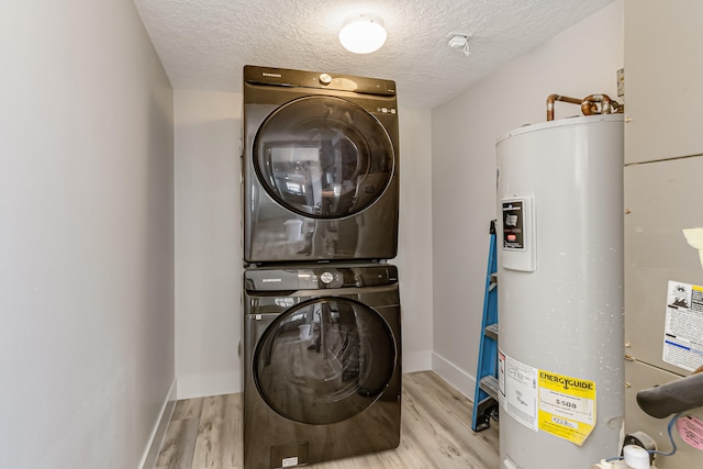 laundry area featuring stacked washer and clothes dryer, a textured ceiling, water heater, and light hardwood / wood-style flooring