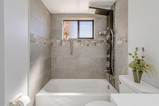 bathroom with toilet and tiled shower / bath combo