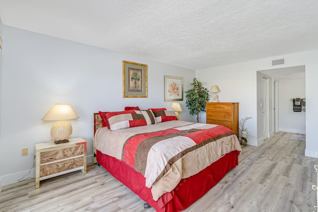 bedroom featuring a textured ceiling and light wood-type flooring