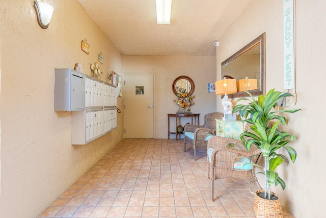 hall with a textured ceiling and light tile floors