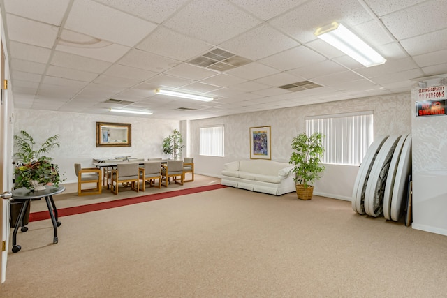 interior space featuring a paneled ceiling and light carpet