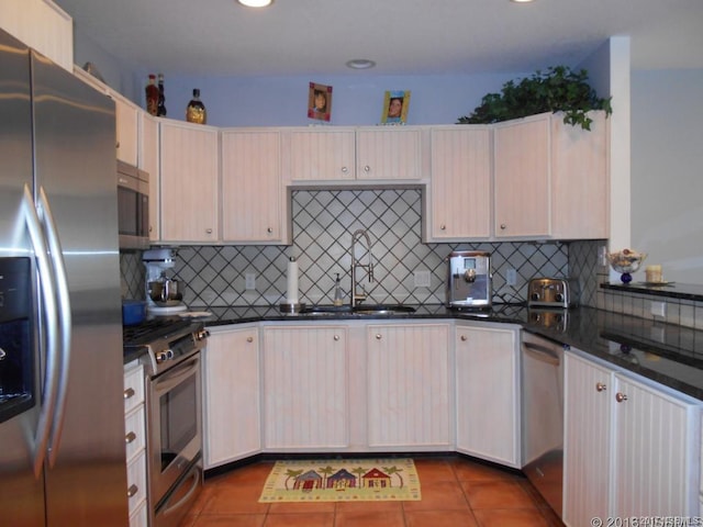 kitchen with tasteful backsplash, appliances with stainless steel finishes, and dark tile flooring