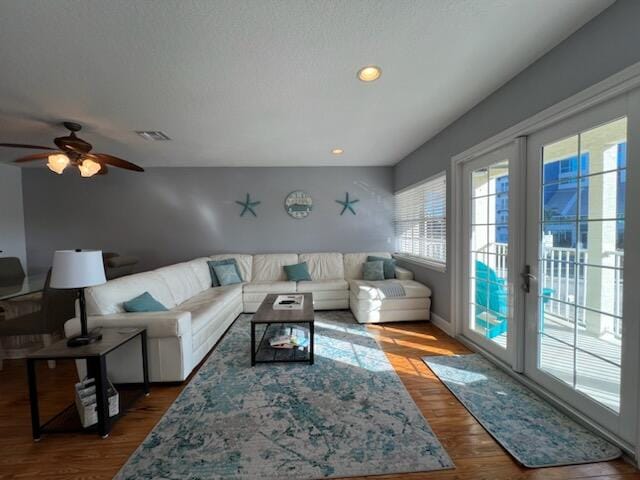 living room with ceiling fan, dark wood-type flooring, and french doors