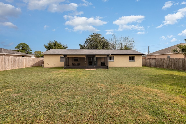 rear view of house featuring a yard