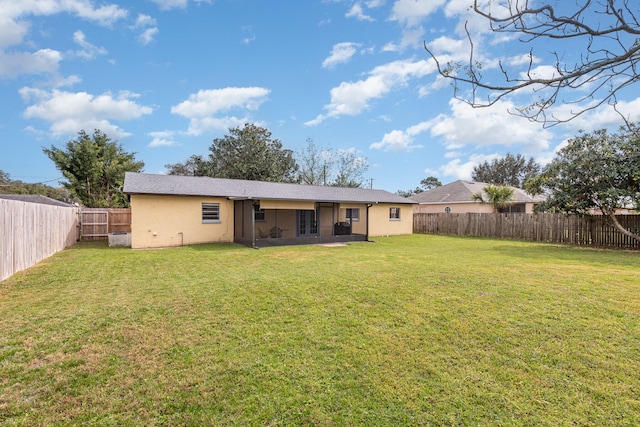 rear view of property featuring a lawn