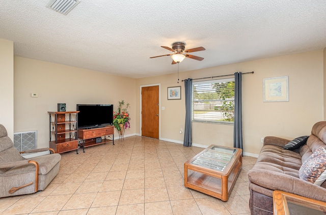 living room featuring light tile flooring, ceiling fan, and a textured ceiling