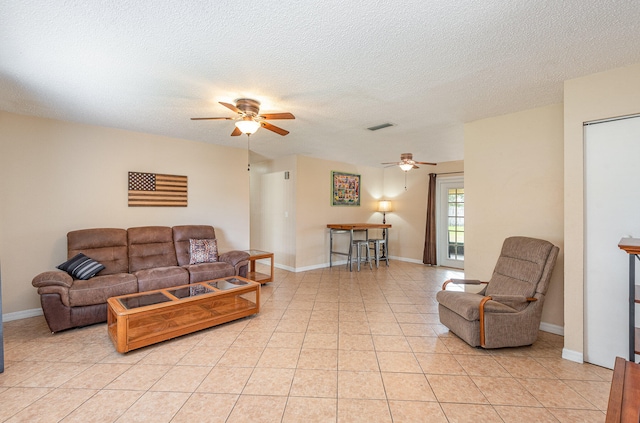 tiled living room with ceiling fan and a textured ceiling