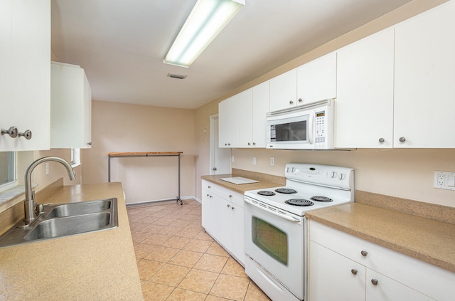 kitchen with light tile flooring, white appliances, white cabinets, and sink