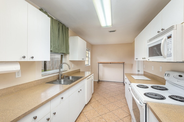 kitchen featuring white appliances, white cabinets, sink, and light tile floors