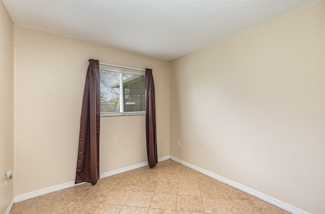 unfurnished room featuring a textured ceiling and light tile floors