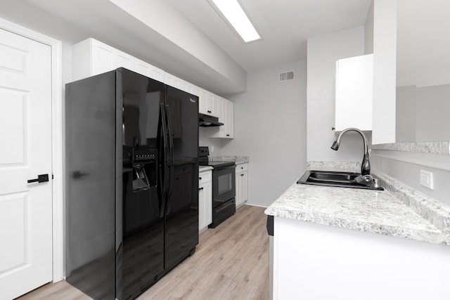 kitchen with white cabinets, light hardwood / wood-style floors, black appliances, and sink