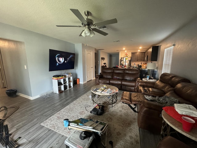 living room featuring a textured ceiling, ceiling fan, and hardwood / wood-style flooring