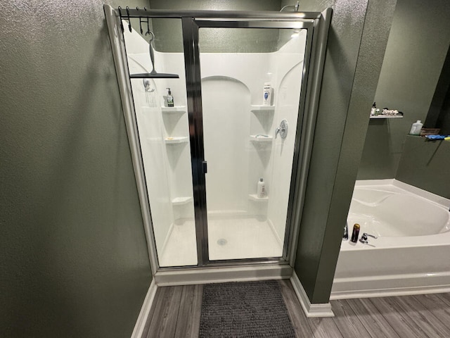 bathroom featuring hardwood / wood-style floors and independent shower and bath