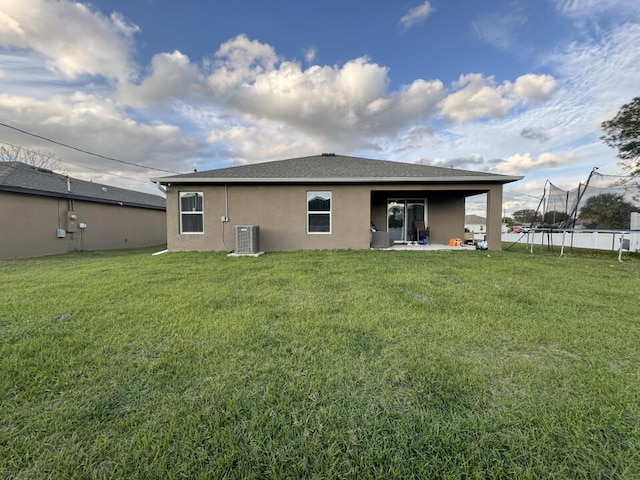 back of property featuring a lawn, a patio, and central AC