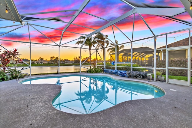 pool at dusk with a patio and a lanai