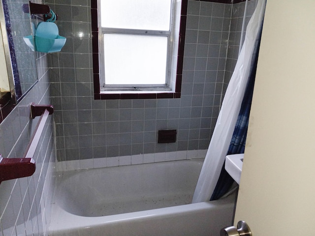 bathroom with tile walls and shower / tub combo with curtain