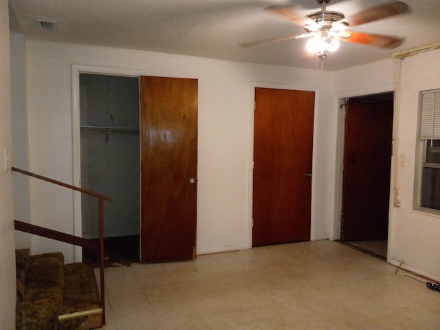 bedroom with light tile flooring, two closets, and ceiling fan