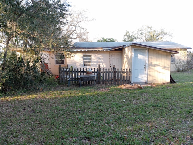 back of property featuring a yard and a shed