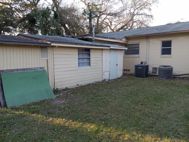 view of side of home featuring central air condition unit and a yard