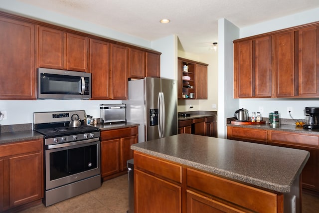 kitchen featuring tile patterned flooring, a kitchen island, and stainless steel appliances