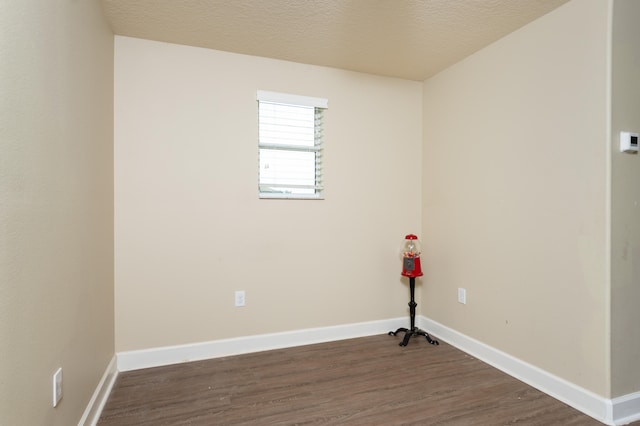 spare room featuring dark hardwood / wood-style flooring and a textured ceiling