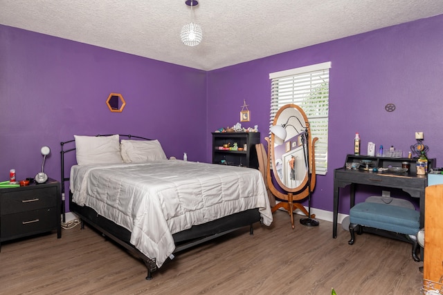 bedroom with a textured ceiling and hardwood / wood-style flooring