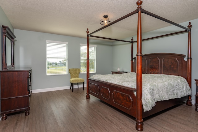 bedroom with a textured ceiling and dark hardwood / wood-style flooring