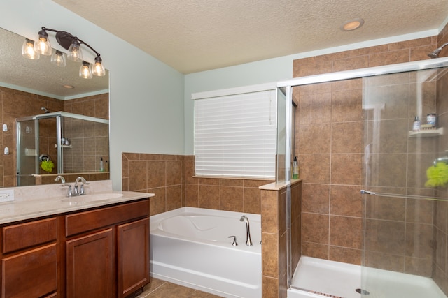 bathroom with vanity, plus walk in shower, a textured ceiling, and tile patterned floors