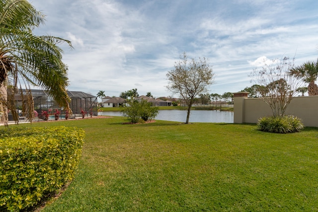 view of yard with a water view and glass enclosure