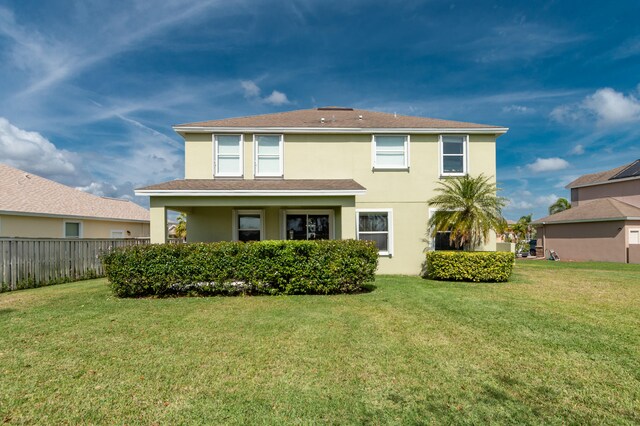 rear view of property featuring a yard