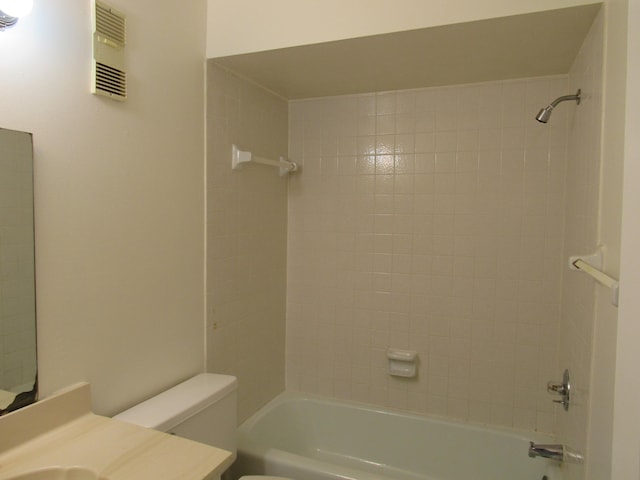 full bathroom with tiled shower / bath, toilet, and vanity