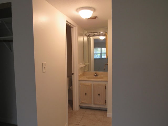 hallway featuring light tile floors and sink